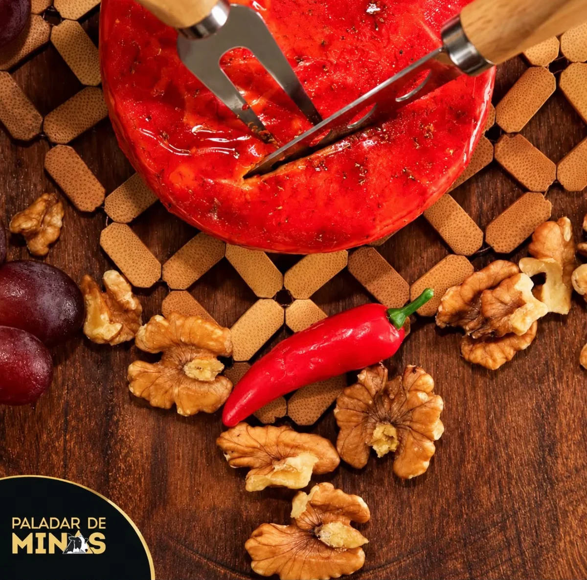 Queijo com pimenta em uma mesa com uvas e nozes